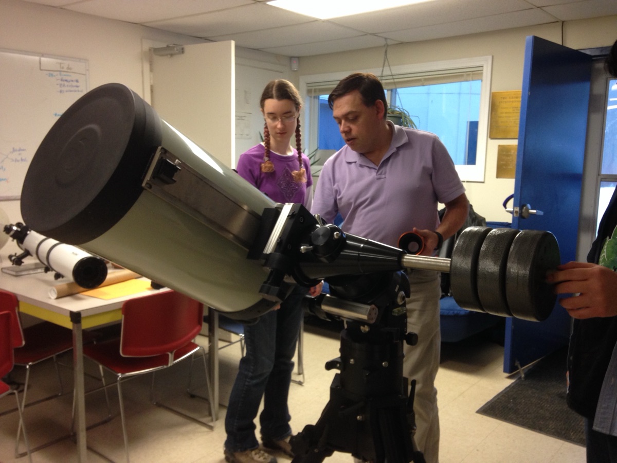 Michael Person guiding a student adjusting a telescope in a teaching lab